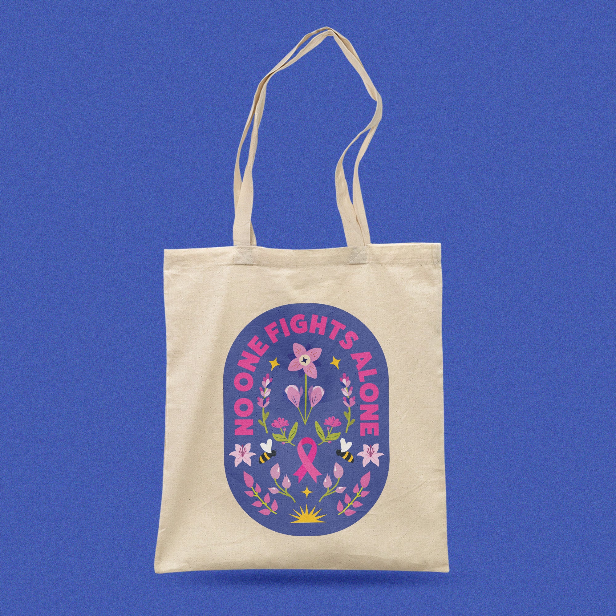 Beige tote bag with a pink ribbon design and 'No One Fights Alone' text affirmation for breast cancer patient